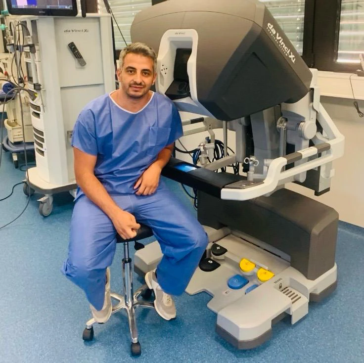Dr. Joseph Gharios beside a robotic surgical system in Lebanon